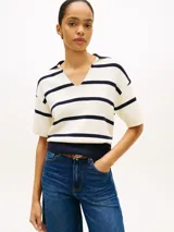Chomba de punto Tommy Hilfiger de corte amplio, con diseño de rayas horizontales blancas y azul marino, manga corta, hombros caídos y cuello en V con solapa.