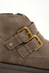 Botas cortas de cuero color visón con suela track, cierre lateral y doble tira con hebillas doradas.