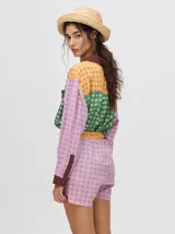 Short de corte boxy confeccionado en viscosa con estampado geométrico de estrellas en tonos rosados. Presenta una pretina elástica en color naranja y cordón de ajuste en color marrón.