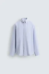 Camisa de corte relajado confeccionada en tejido de algodón con estampado de cuadros pequeños. Presenta cuello abotonado, cierre frontal con botones y manga larga con puños abotonados.