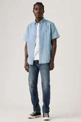 Pantalón de jean corte regular taper, con diseño de cinco bolsillos, cierre de botón y cremallera, y acabado en tono azul medio con efecto desgastado.