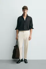Pantalón regular fit color negro de tejido con viscosa, con cintura elástica ajustable con cordón, bolsillos frontales y traseros.