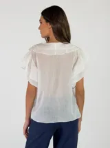 Blusa de algodón color blanco, con cuello en V y detalles de volados en el frente y mangas cortas.