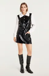 Campera negra de cuero sintético con mangas largas de punto acanalado color crema.