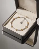 Pulsera de plata 925 con baño de oro, compuesta por una cadena de eslabones rectangulares pavimentados con circonias blancas, intercalados con discos dorados lisos.