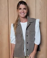 Chaleco de estilo utilitario en color gris desgastado, con cuello camisero, cierre frontal de botones y dos bolsillos frontales con solapa.
