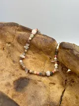 Collar corto con cuentas de piedras naturales en tonos rosados, beige y plateado.