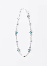 Pulsera de plata 925 con cadena de eslabones, adornada con pequeñas esferas y dijes de ojo turco.