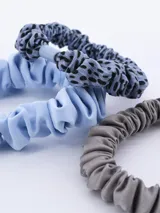 Pack de tres coleros para el pelo, uno color crema, uno con estampado dálmata y uno negro.