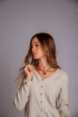 Blusa de morley elastizado color blanco, con escote en V y botones dorados.