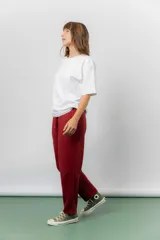 Pantalón jogger de calce relajado color bordó intenso, con cintura elastizada y lazo regulable. Cuenta con bolsillos laterales con cierre invisible y silueta recta levemente afinada.