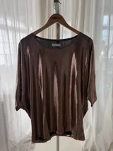 Remera amplia con acabado de glitter color bronce, cuello redondo y mangas 3/4.