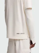 Remera de algodón Moncler Grenoble en color blanco roto con diseño de doble capa. Cuenta con cuello alto, cierre de cremallera corta, logo en el pecho y mangas largas con orificios para el pulgar y detalles tricolores.