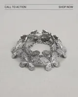 Cinto de metal plateado compuesto por dijes unidos en forma de mariposas con textura granulada.