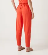 Pantalón jogger color naranja, con cintura elástica, hebilla y bolsillos laterales.