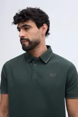 Remera polo bordó con textura sutil, cuello y puños acanalados con línea oscura de contraste, cierre frontal parcial de dos botones y logo bordado en el pecho.