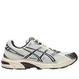 Championes Asics modelo Gel-1130, color blanco con detalles en marrón y plateado, confeccionados en malla transpirable y superposiciones sintéticas.