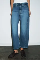 Jeans de tiro medio con corte relajado y largo al tobillo. Presenta diseño de cinco bolsillos, trabillas en la cintura y cierre frontal con cremallera y botón metálico.