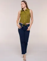 Camisa sin mangas de rayón texturado color blanco, de corte crop con cierre frontal de botones y lazos para anudar en el frente. Cuenta con cuello camisero, detalles de brillos en los hombros y bolsillos plaqué con solapa en el pecho.