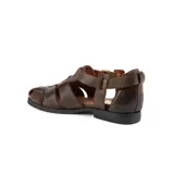 Sandalias bajas de cuero color chocolate, con tiras entrecruzadas y hebilla dorada al tobillo.