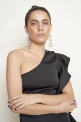 Vestido corto negro de un solo hombro con diseño ajustado y volados decorativos a lo largo del lateral izquierdo.
