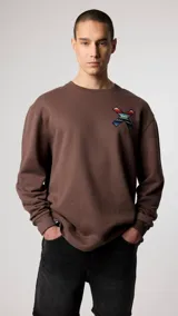 Buzo marrón de corte clásico con cuello redondo y logo bordado en el pecho.