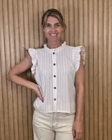 Musculosa a rayas blancas y rosadas con cuello alto fruncido, volados en las sisas y cierre frontal con botones oscuros.