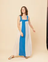 Vestido largo de lino color crema con panel central azul. Tiene escote recto, breteles anchos, elástico en la espalda y tajos laterales.
