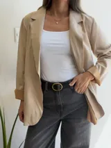 Blazer de línea italiana con textura efecto ante, de corte recto y diseño clásico. Presenta solapas frontales, cierre de un botón y bolsillos decorativos. Confeccionado en tejido suave con elasticidad.