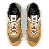 Championes New Balance 574 unisex color marrón con detalles en verde y blanco.