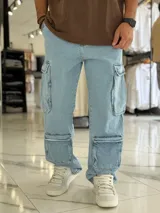 Pantalón de jean estilo cargo, color azul, de corte ancho y holgado, con múltiples bolsillos laterales en muslos y pantorrillas.