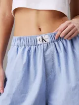 Shorts tipo bóxer de denim celeste, con cintura elástica con logo de Calvin Klein.
