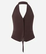 Chaleco de sastrería color marrón, con diseño de frente única y cuello halter. Presenta pinzas laterales que definen la silueta, bolsillos decorativos y ruedo levemente redondeado. En la espalda, cuenta con una cinta ajustable con ojal metálico y tiras largas.