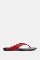 Sandalia plana de piel con diseño de dedo, suela baja y tiras rojas.
