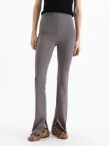 Pantalon de microfibra color gris, de corte ajustado en la parte superior y botamangas acampanadas con aberturas laterales.