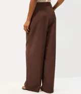 Pantalón de sastrería corte recto color gris, con bolsillos laterales tipo cuchillo y trabillas para cinturón.