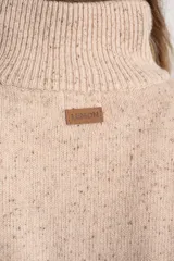 Sweater de lana y nylon, color beige jaspeado con rayas horizontales marrones oscuras. Presenta cuello alto con abertura frontal abotonada con tres botones marrones.