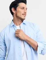 Camisa sport de manga larga con cuello buttondown, confeccionada en una mezcla de algodón y lino. Presenta un diseño clásico en color celeste con cierre frontal de botones.