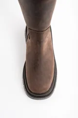 Bota de caña media confeccionada en cuero legítimo con efecto lavado. Presenta una suela track robusta de goma con relieve y costuras reforzadas en el cuerpo de la bota.