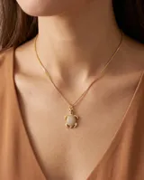 Collar de bronce dorado con cadena fina y dije en forma de tortuga con caparazón pavimentado de circonias y pequeños detalles en color negro.