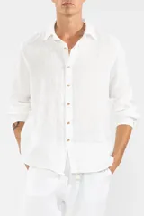 Camisa blanca de manga larga confeccionada en lino 100%, con calce recto y relajado. Presenta frente abotonado con botones de coco con logo y parche Polonio.