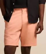 Bermuda masculina de sarga en color blanco, con cierre frontal de botón y cremallera, trabillas para cinturón y bolsillos laterales.