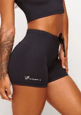 Short deportivo negro de tiro alto, confeccionado en poliamida y elastano. Presenta cordones ajustables en la cintura y logo de la marca en la pierna izquierda.