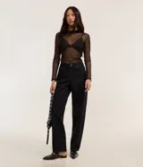 Pantalón baggy de corte holgado y tiro alto, confeccionado en sarga de algodón con estampado animal print de leopardo en tonos oscuros. Cuenta con trabillas en la cintura, cierre frontal con botón y cremallera, y bolsillos en la parte delantera y trasera.