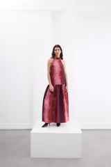 Vestido largo negro de crepe texturado con escote halter, cuello alto con volados y diseño holgado.