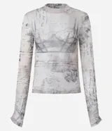 Blusa de manga larga y cuello alto en tejido de tul transparente, con estampado que simula textos manuscritos y un diseño gráfico de corsé en tonos grises y rosados.