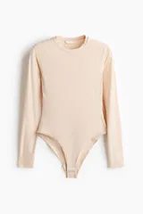Body de manga larga en punto elástico de color beige, con escote redondo y diseño ajustado al cuerpo.