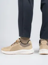 Zapatillas urbanas Hush Puppies con capellada de cuero perforado en tono beige, suela con tecnología Spinal de amortiguación y base de goma para mayor tracción.