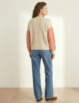 Cardigan de punto con escote en V y abotonadura frontal. Presenta un diseño colorblock con paneles en beige claro, rosa salmón y beige con lentejuelas dispersas. Las mangas son largas y abullonadas con puños y ruedo en punto acanalado beige claro.