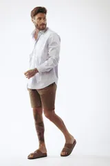 Camisa celeste a rayas verticales blancas, de corte clásico, manga larga y cuello abotonado.